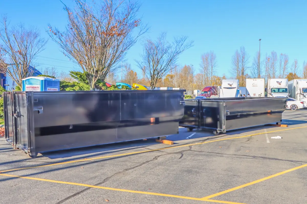 Professional dumpster rental service with roll-off container on residential driveway in Vergennes